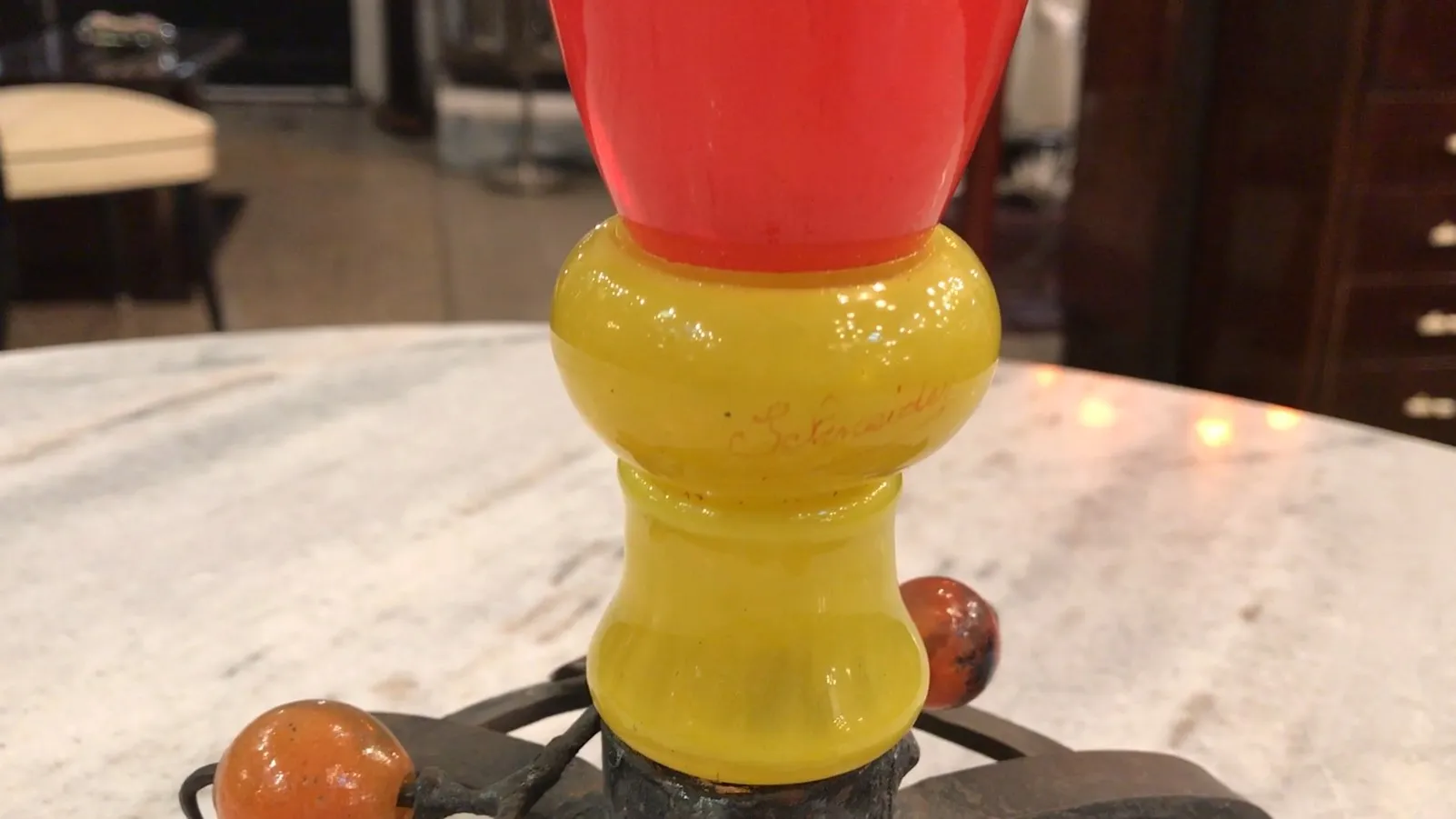 signed glass schneider in bright colors, on a table