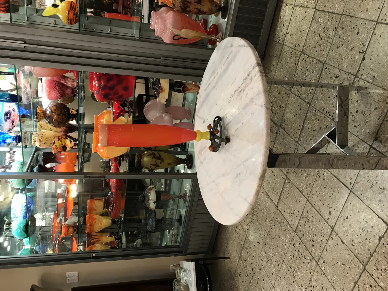 stilisiertes antikes signiertes Glas in einer bunten Vitrine