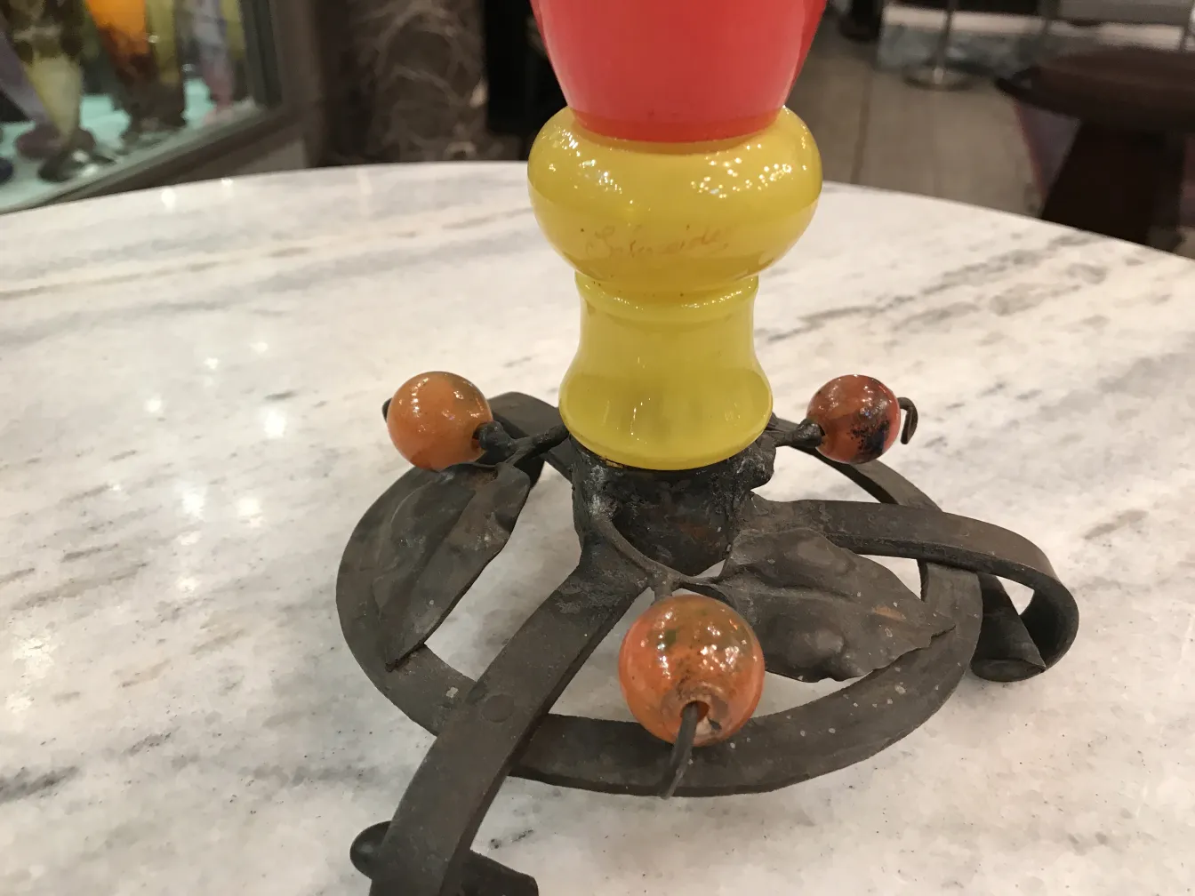 Vista de una antigüedad, vidrio firmado Schneider en color amarillo y rojo con detalles decorativos.