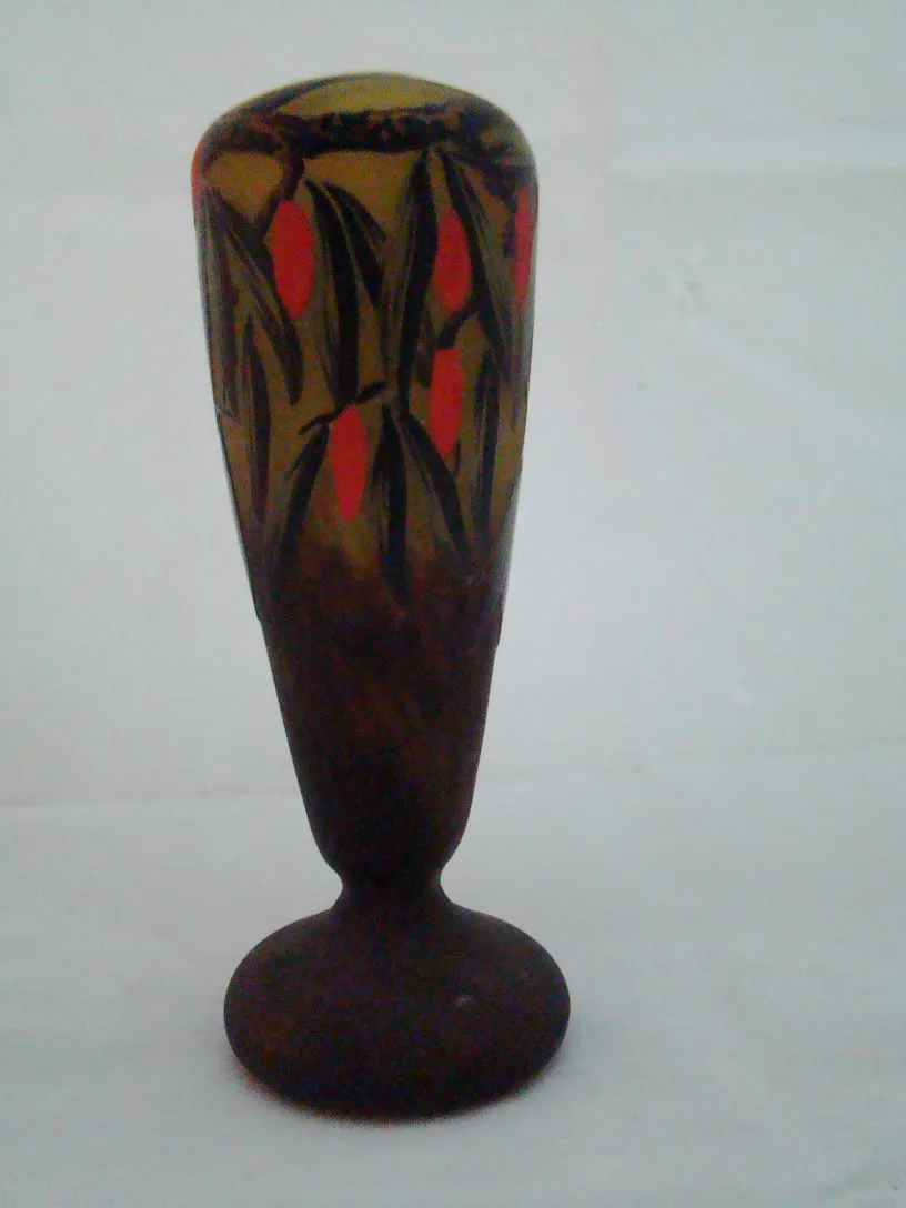 Vidrio antiguo decorado con un diseño floral en tonos morados y rojos.