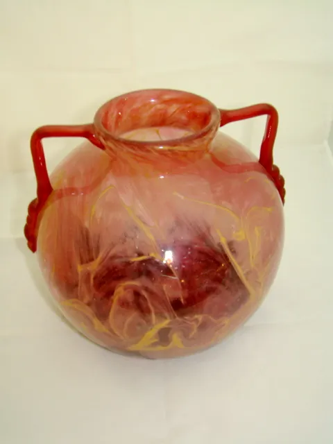 glasgefäß mit roten griffen und buntem design