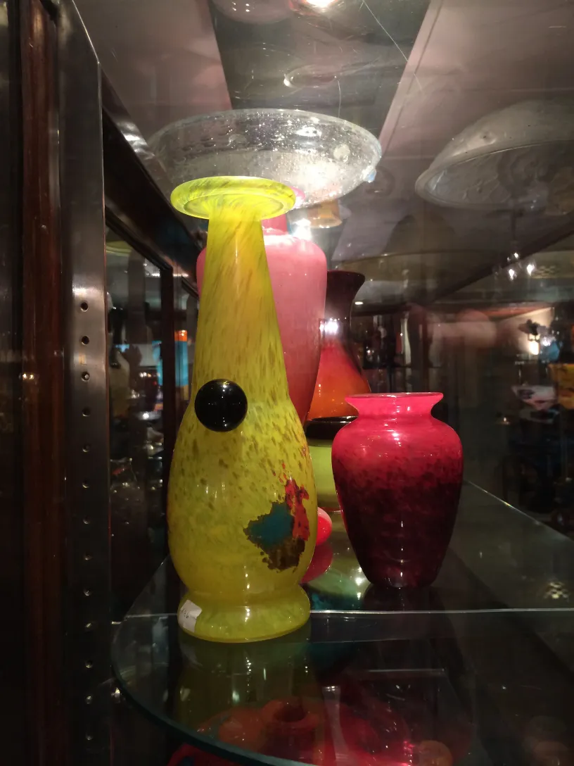 Antique signed glass with colorful design and unique shape in a cozy display.