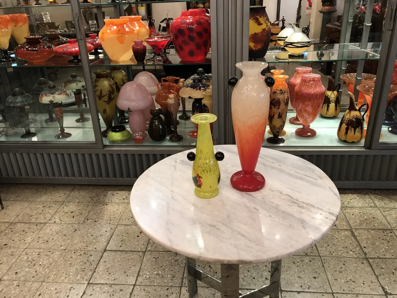 two glass vases on a table, one yellow and the other red