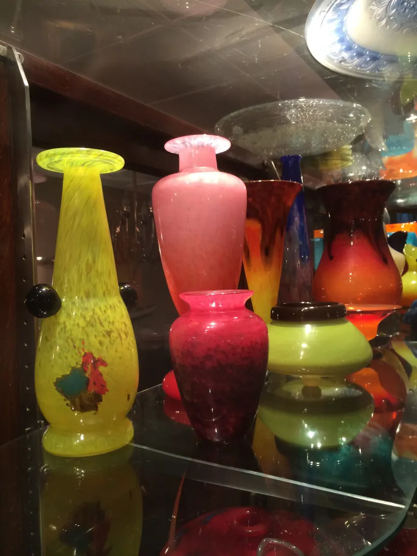 多种古老的玻璃花瓶，有些颜色不同，展示在架子上