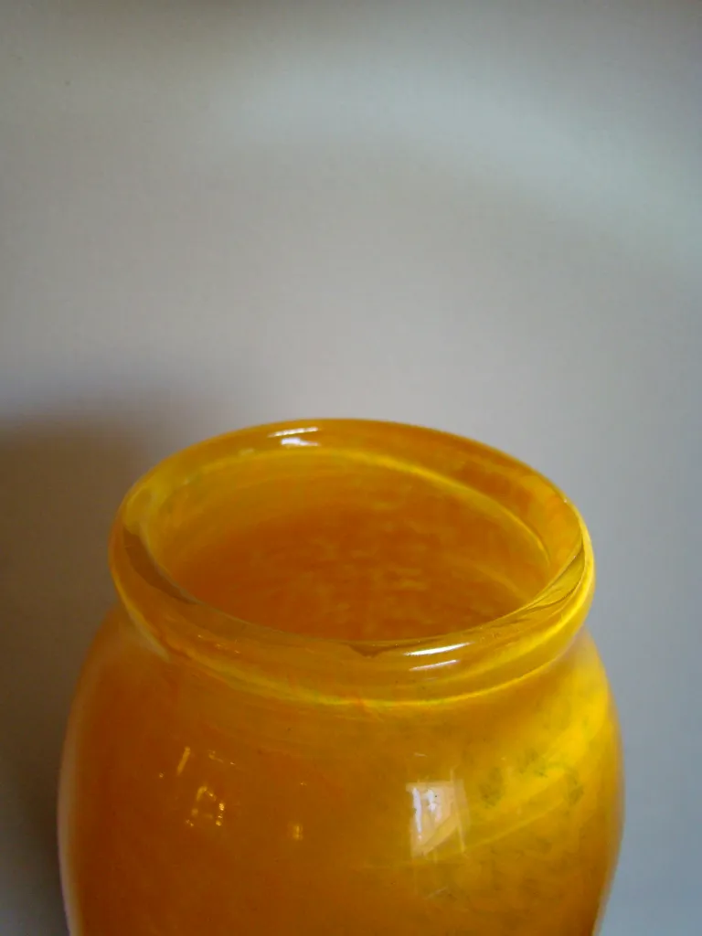 frontal de un vaso amarillo antigüedad con firma visible