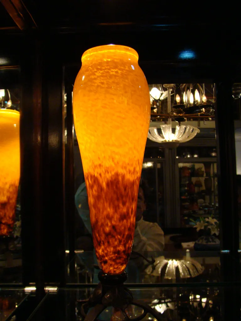 زجاجة شفافة موقّعة من schneider باللون العنبر بتصميم فريد، موضوعة في مرفق عرض.