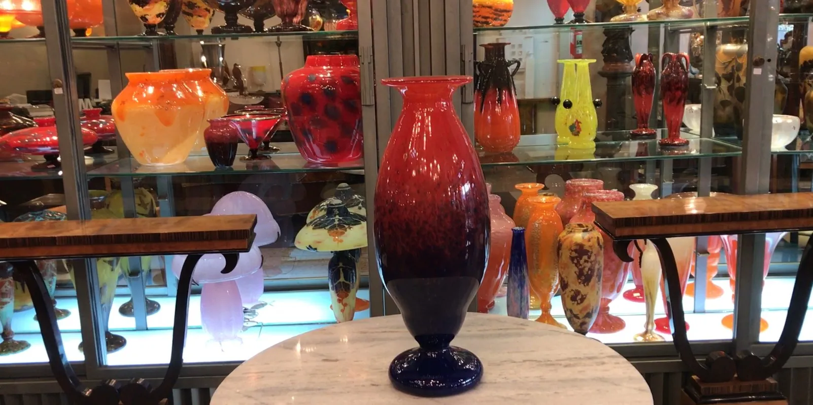 signed glass vase in an antique display setting