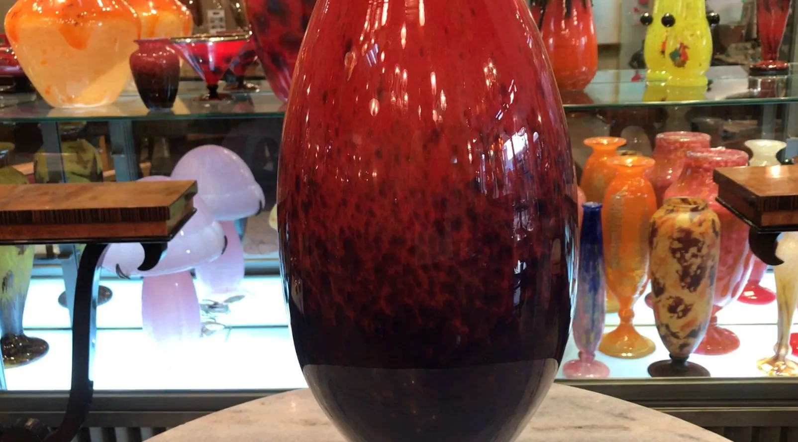signed glass schneider in shades of red and black with oval shape