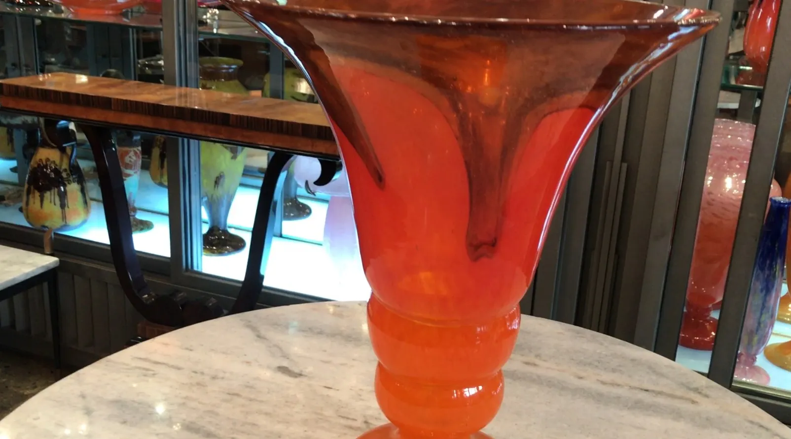 Verre signé par Schneider avec des couleurs vives. Atmosphère vintage avec d'autres objets.