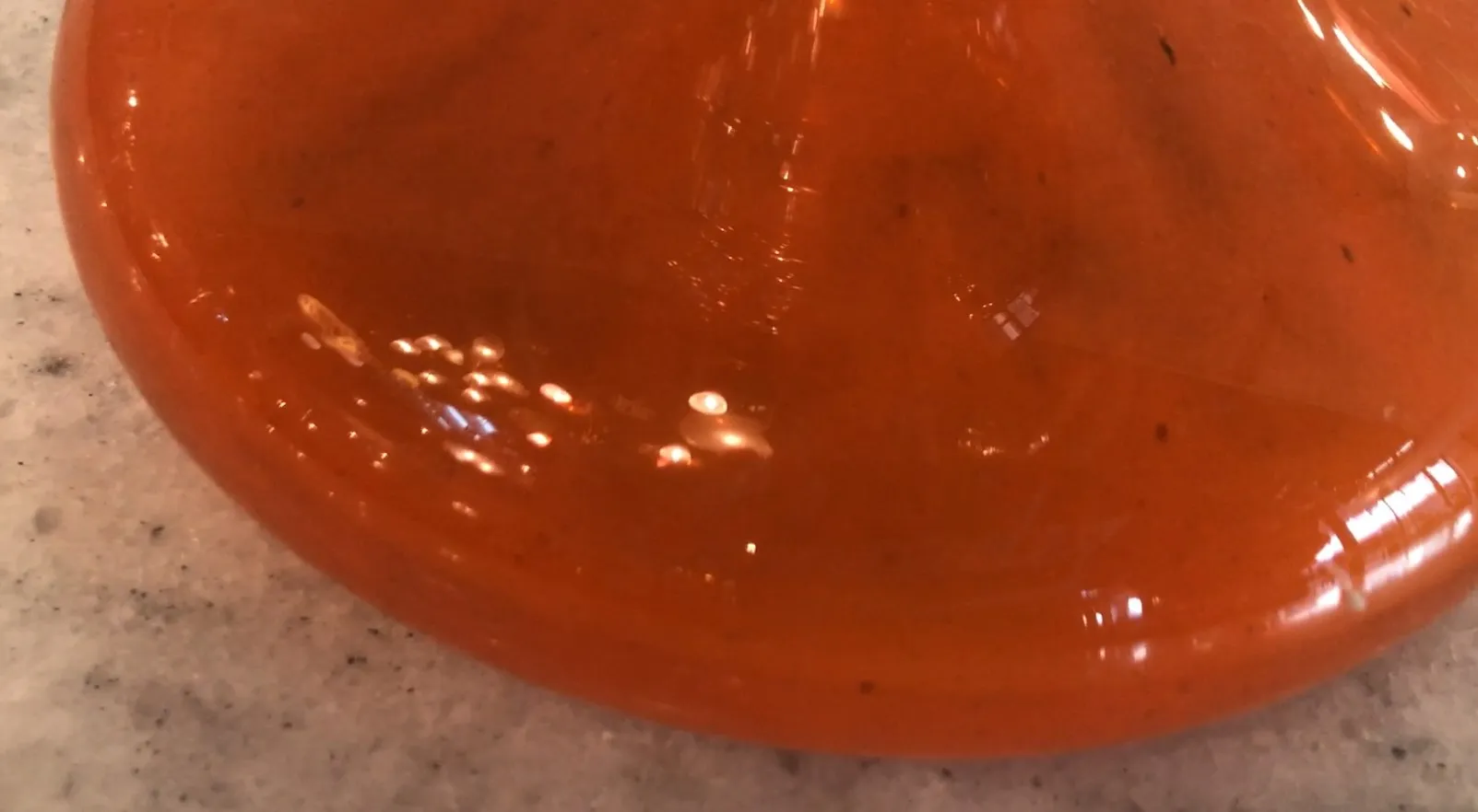 Dettagli di un vetro firmato antico, colori vivaci e forma decorativa.