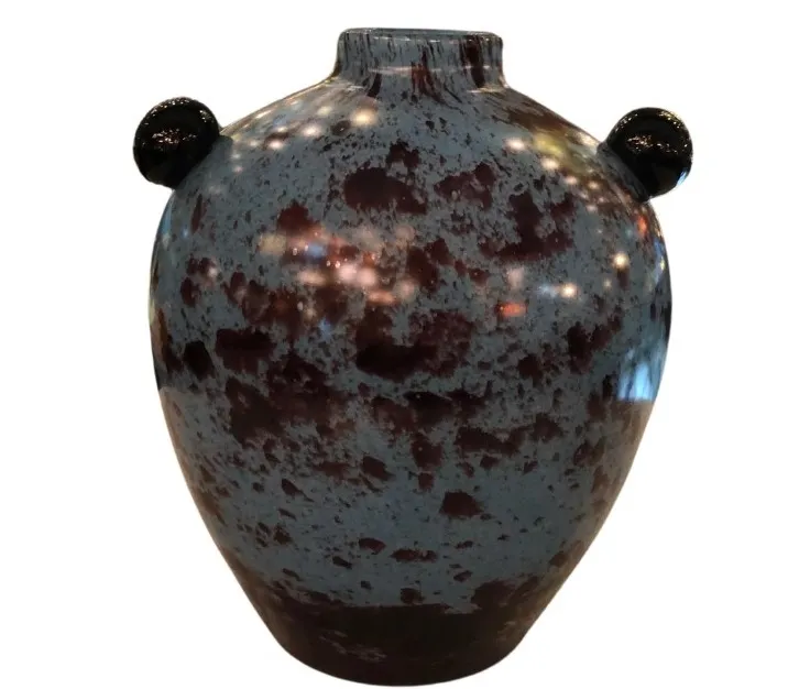 antique glass with two handles, striking design and dark tones