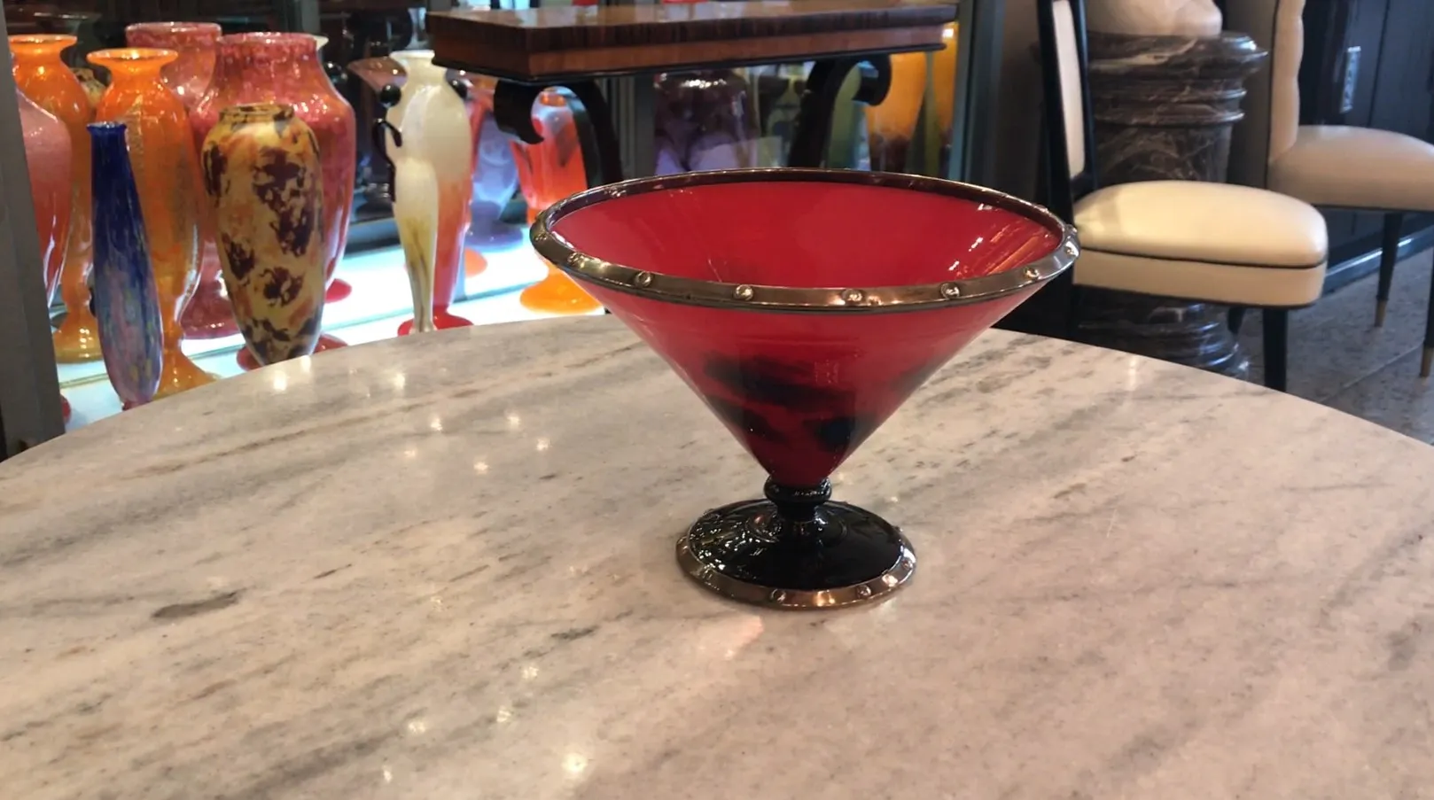 view of an elegant red glass with black base and silver details