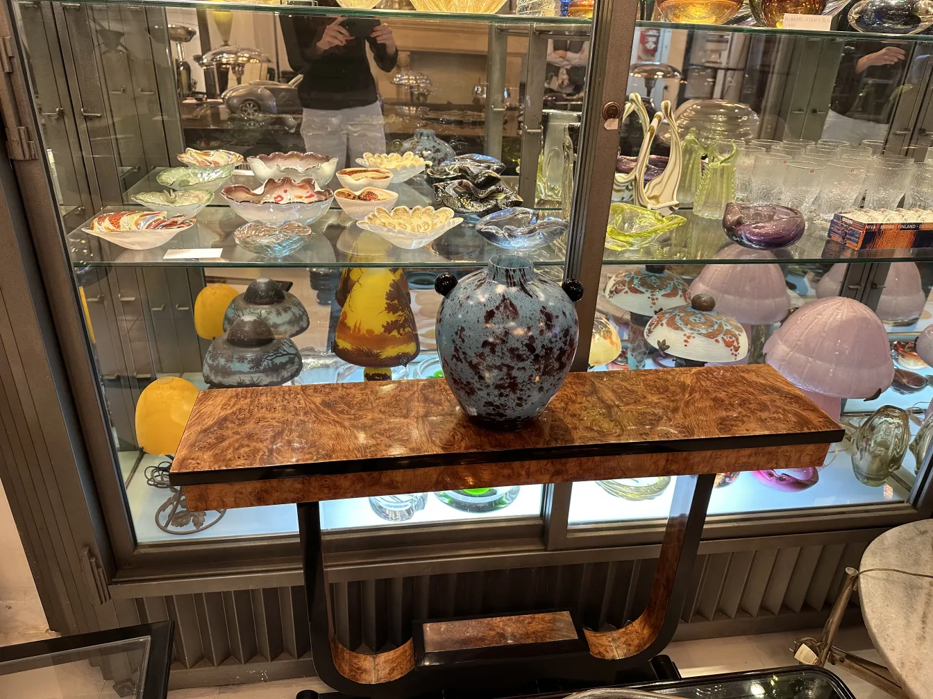 signiertes Glas in einer Vitrine mit bunten Antiquitäten