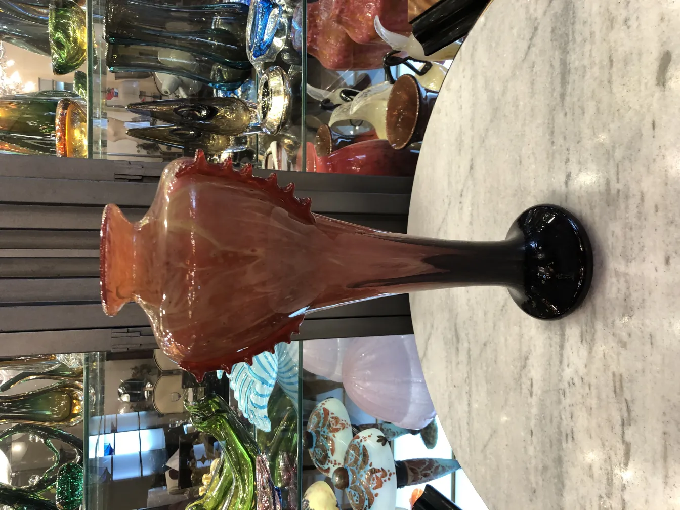 مزراب زجاجي قديم بتفاصيل حمراء وسوداء، خلفية مزينة بالأنتيكات.