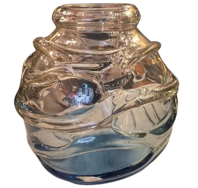 glas mit geschwungenem design und künstlerischen details, subtil blauer hintergrund