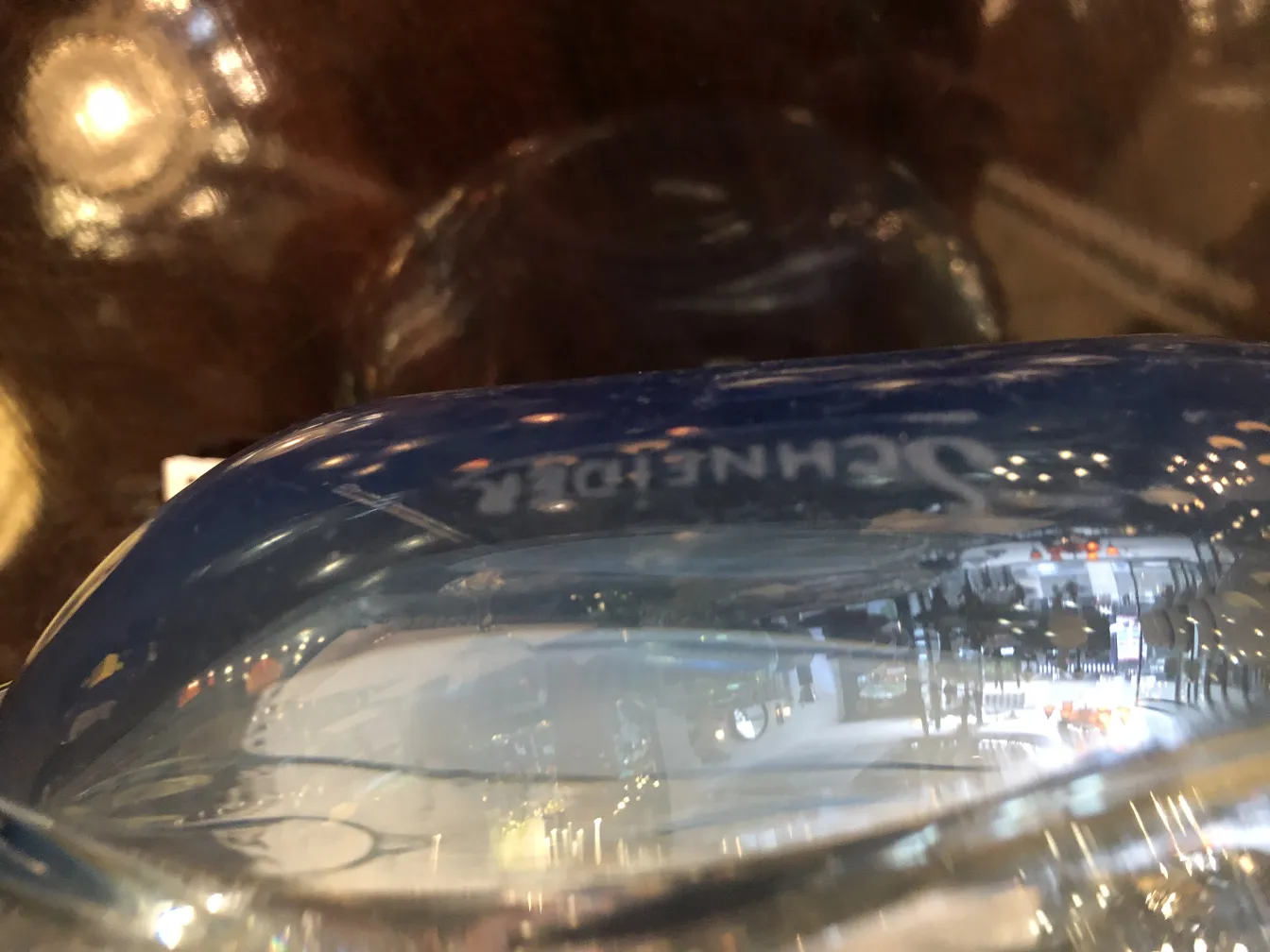 Gros plan sur verre signé Schneider sur fond sombre