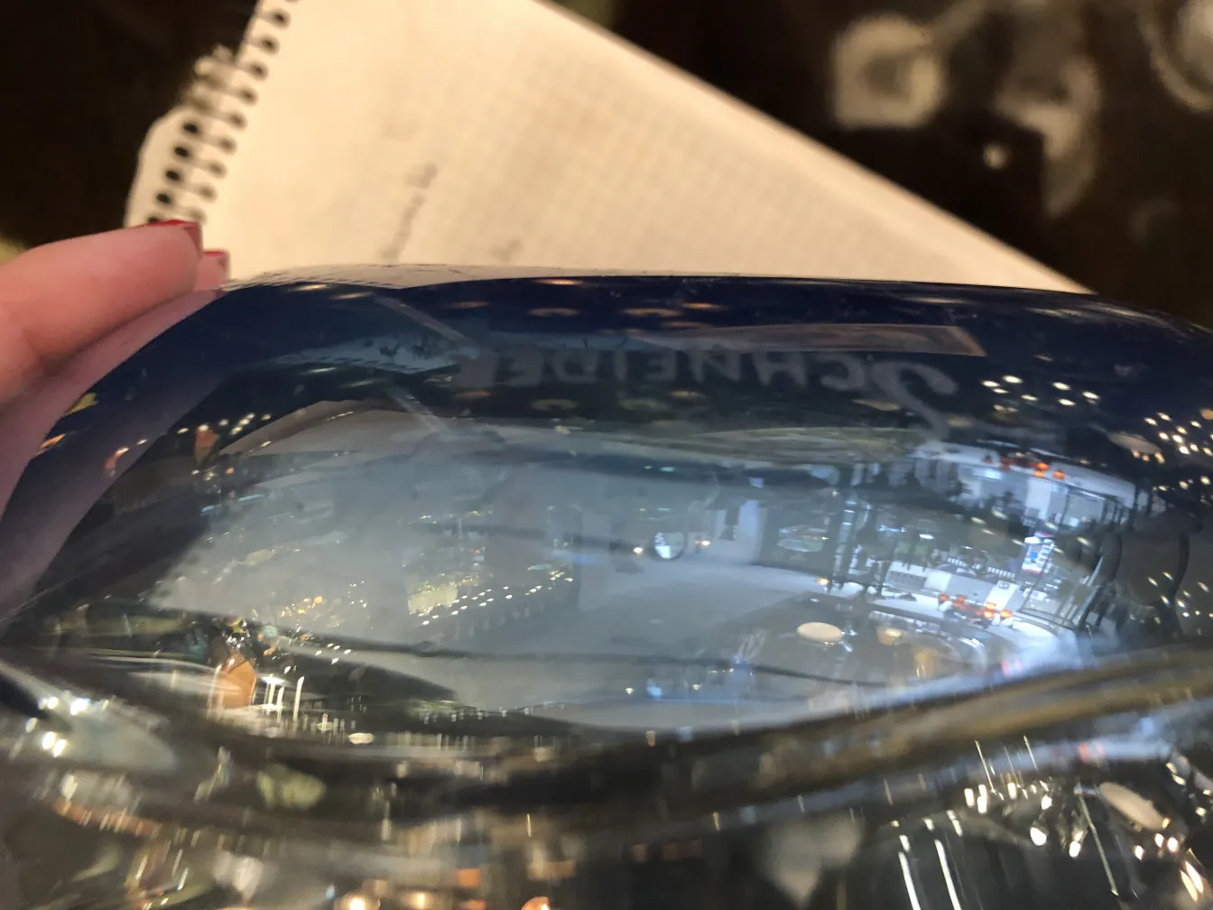 blaues-glas-mit-schneider-unterschrift-hintergrund-mit-lichtern