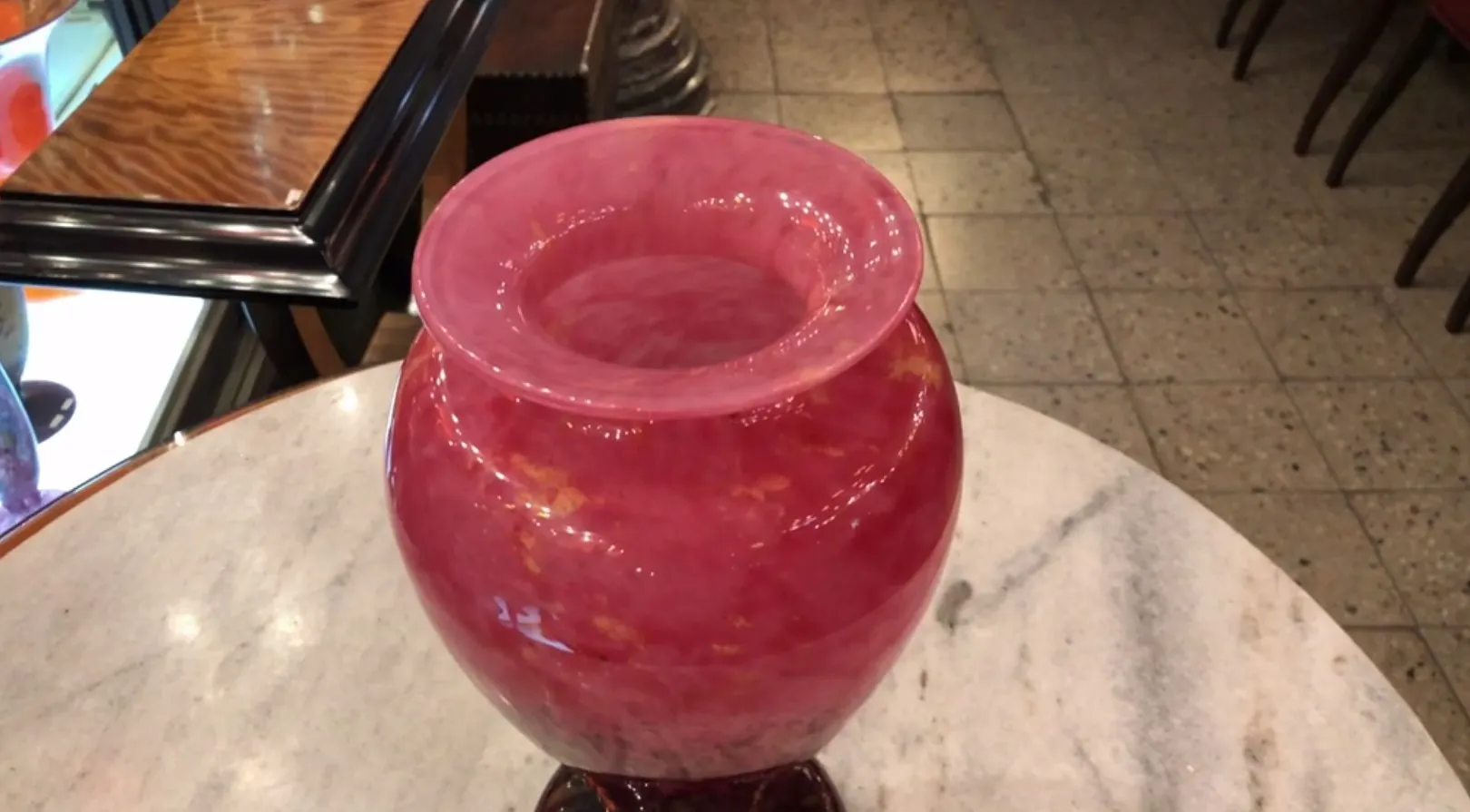 vase antico in vetro con tonalità rosa e dettagli dorati, sfondo in marmo chiaro