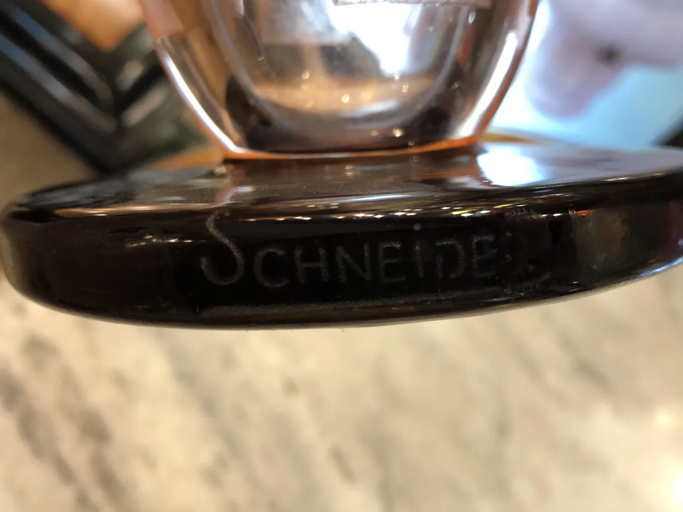 Antikes Glas mit sichtlicher Unterschrift von Schneider. Unschärfer Hintergrund.