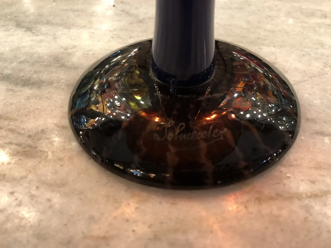 Base of an antique signed glass by Schneider, featuring bright reflections.