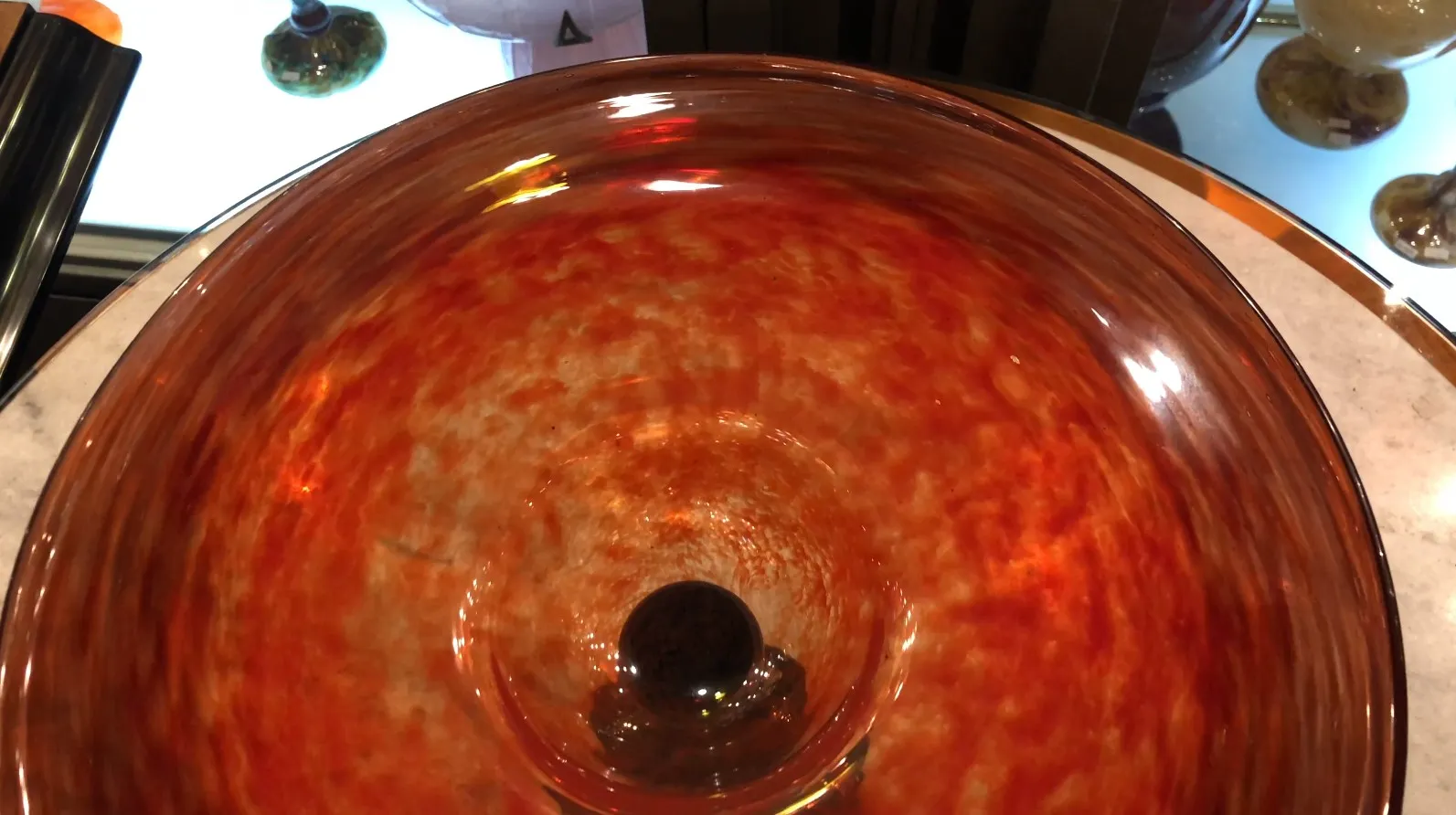 Verre signé de Schneider aux tons chauds avec des détails rouges.