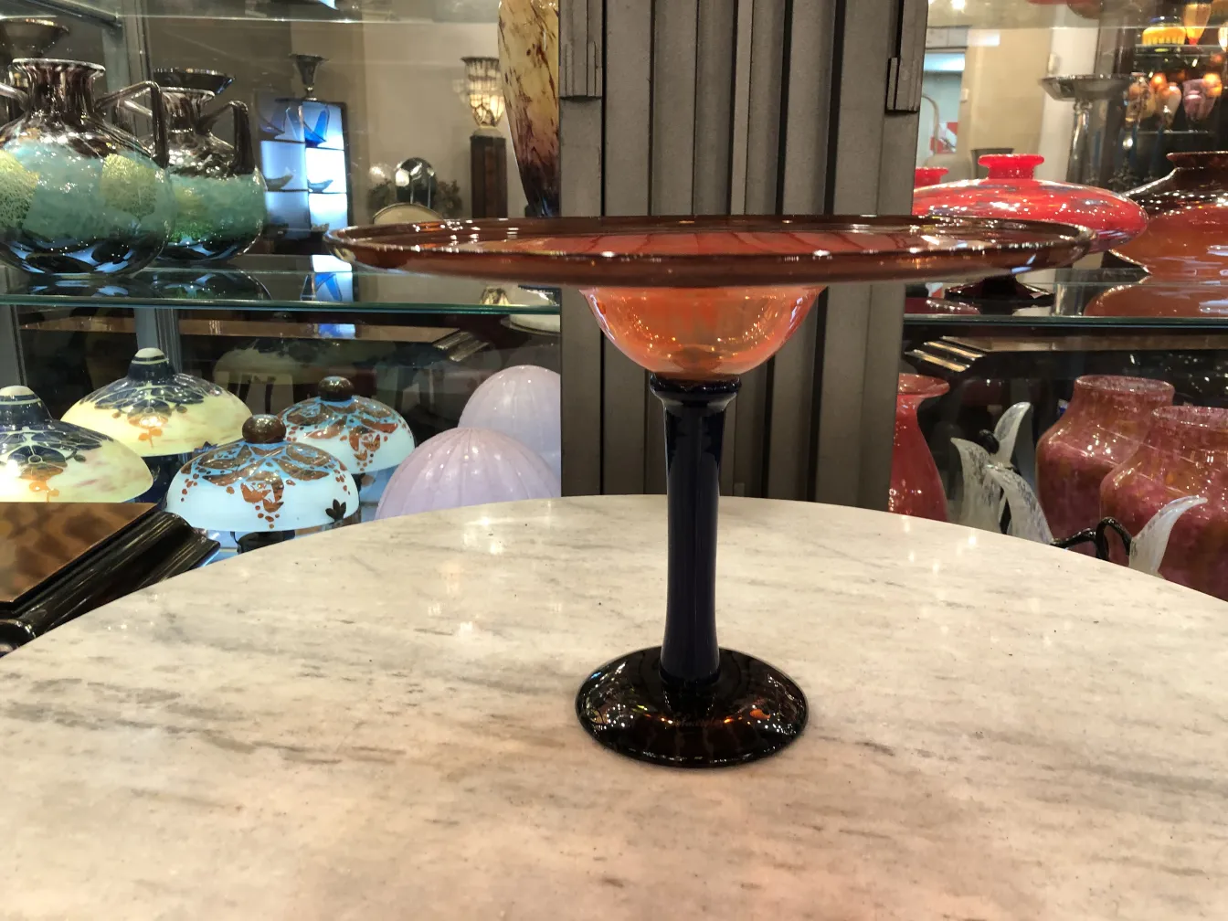 Vidro assinado Schneider com base dupla em laranja e azul, contexto antigo.