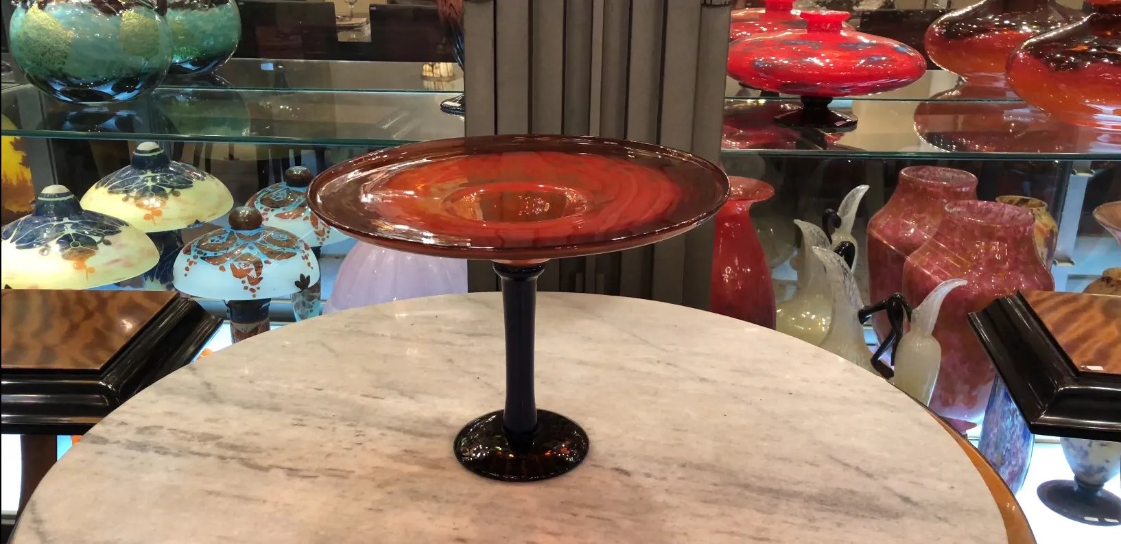 signiertes Glas mit schwarzem Fuß auf einem Tisch