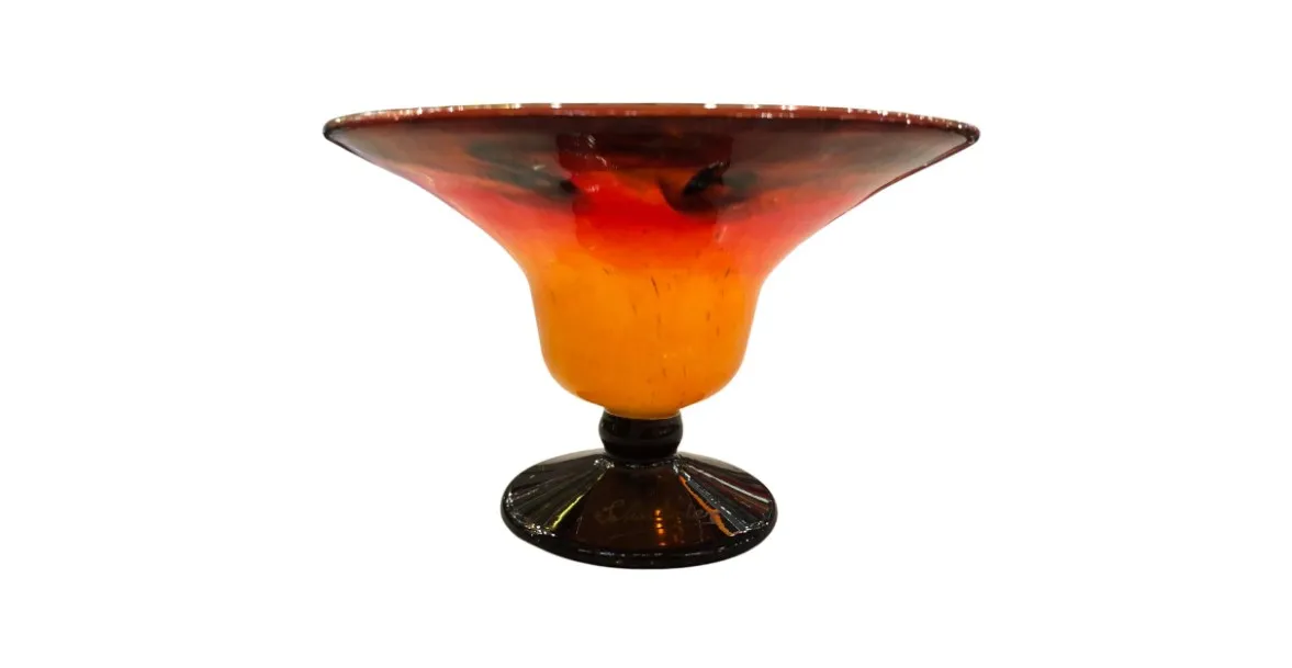 antique glass cup with a dark base and warm colors in the bowl.