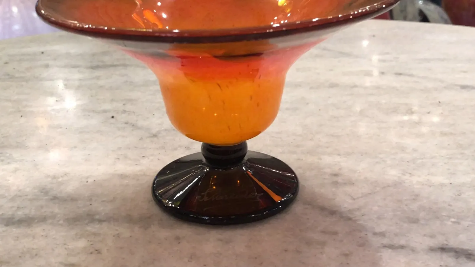 Antique signed glass in amber color with black base.