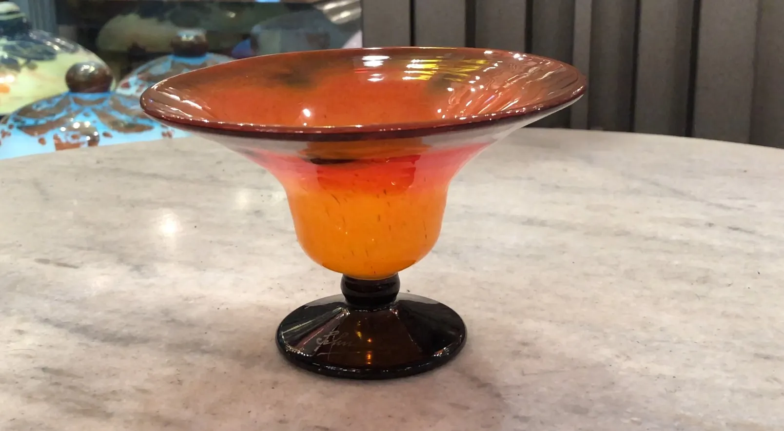 Vetro firmato antico di Schneider con design colorato, posato su una superficie chiara.