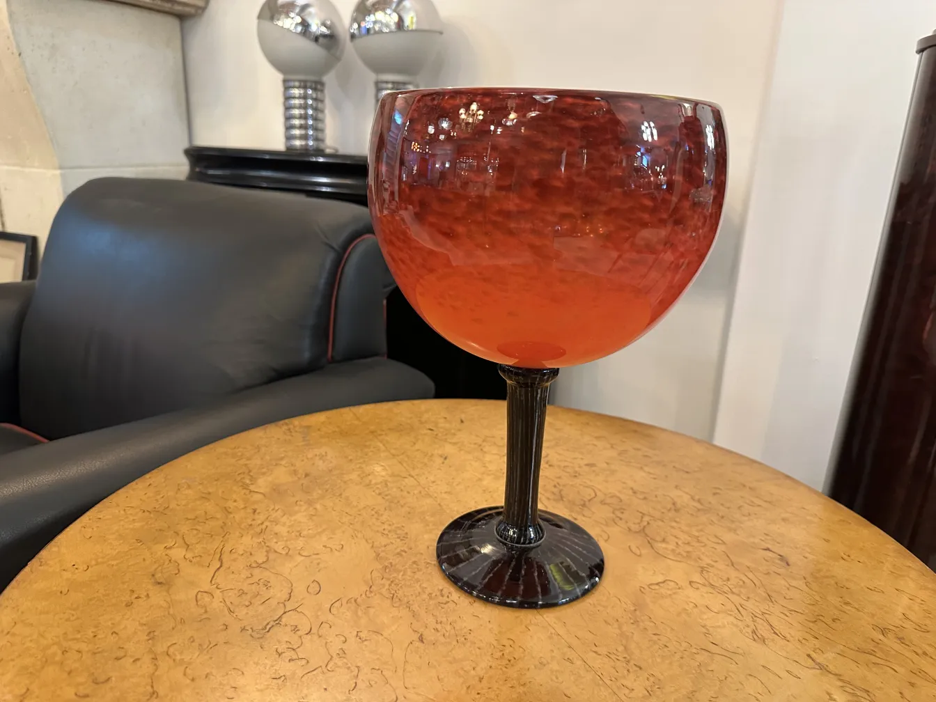 rotes, signiertes Glas in Kelchform mit schwarzem Fuß