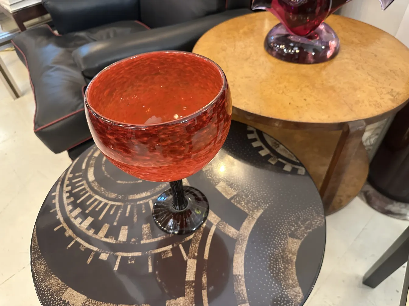 Verre rouge signé sur pied noir, cadre élégant