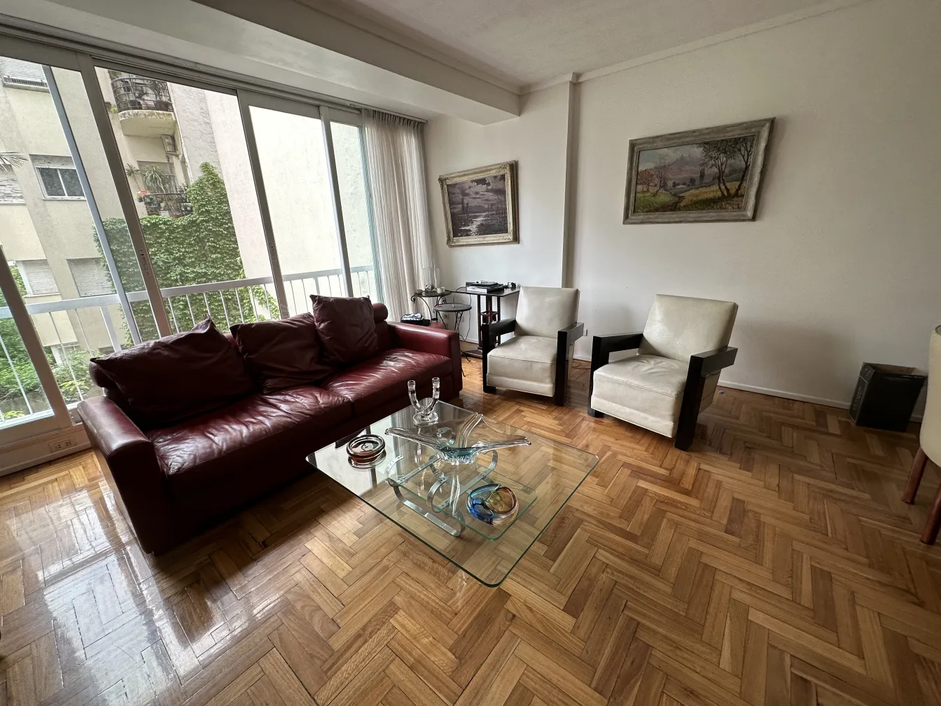 sofá e cadeiras em uma sala com cristal de murano na mesa