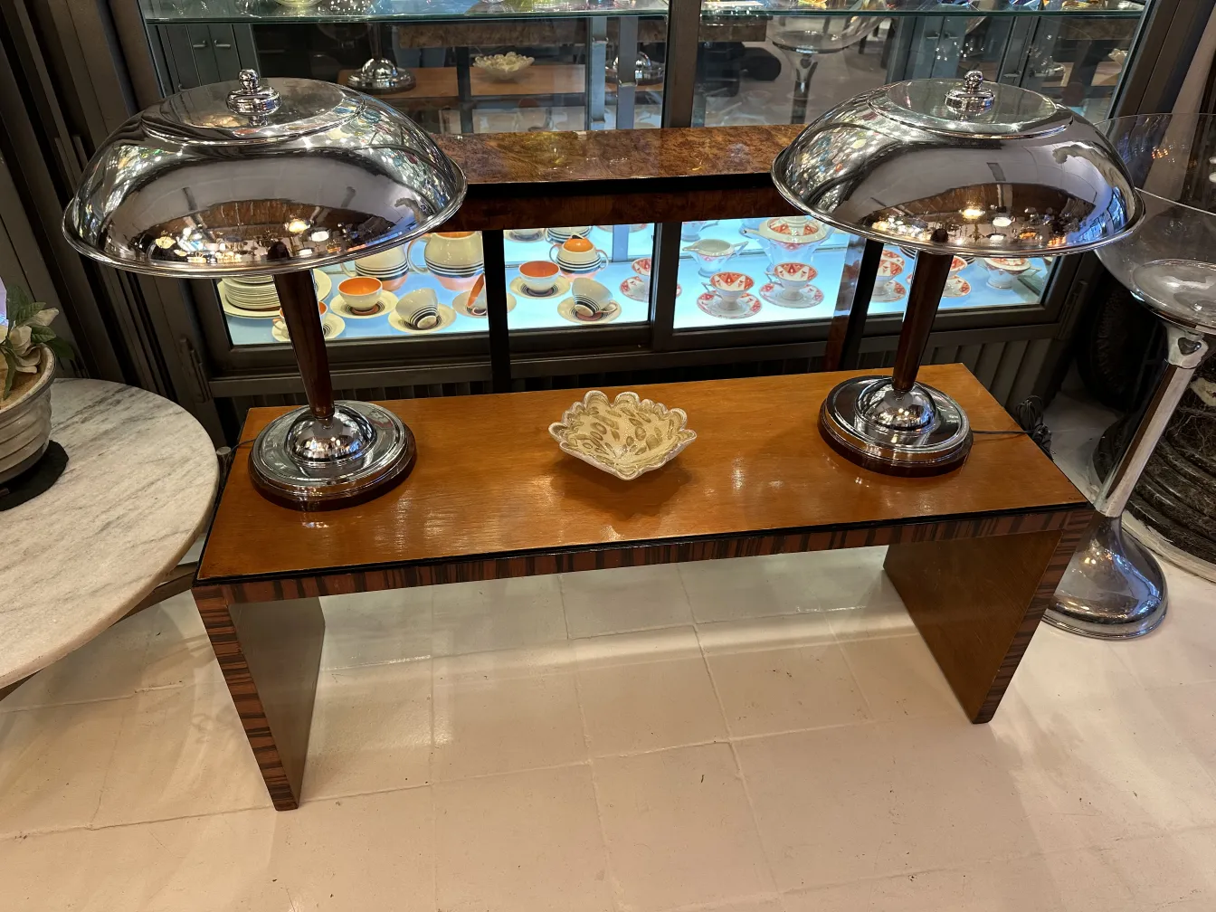 two antique lamps on a shiny wooden table