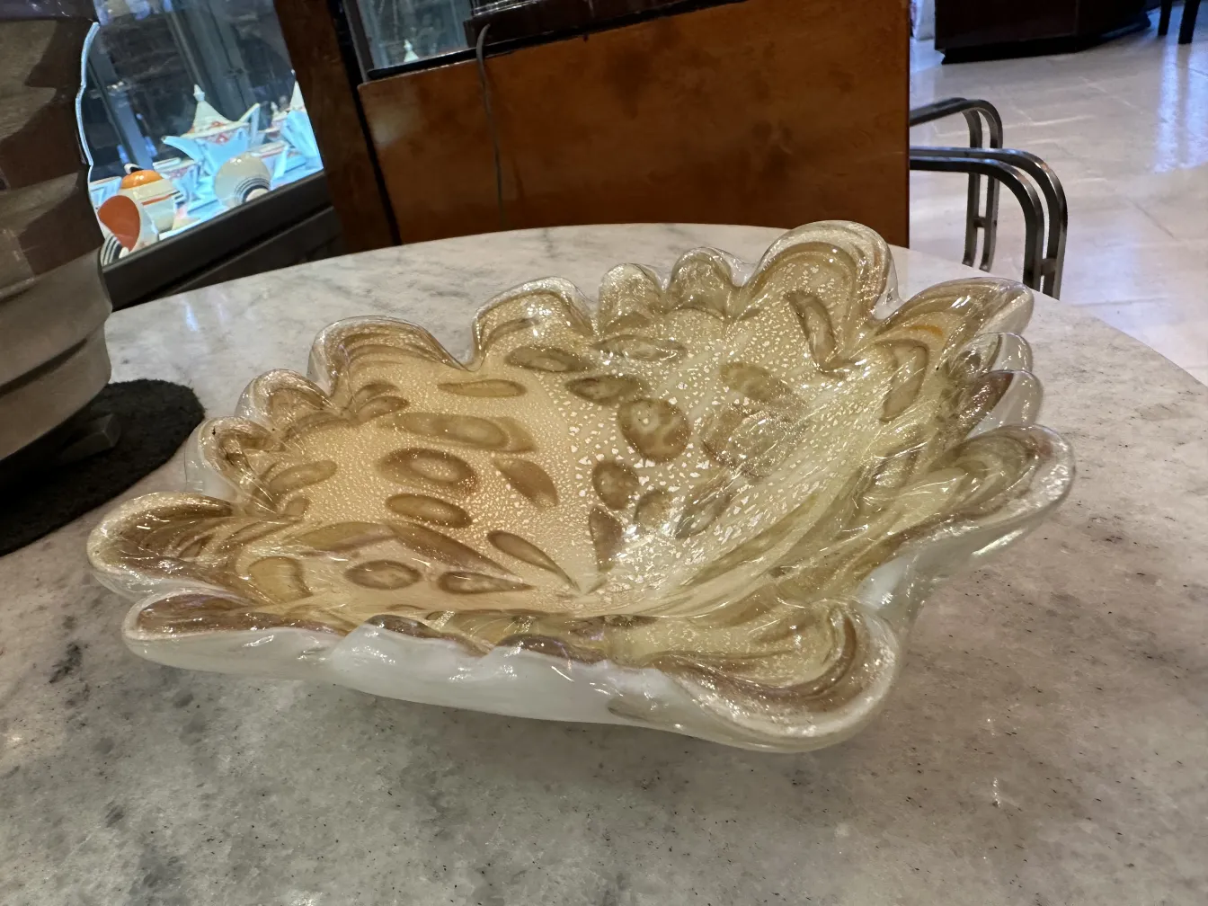 tigela de vidro de murano antigo com detalhes dourados em um fundo neutro