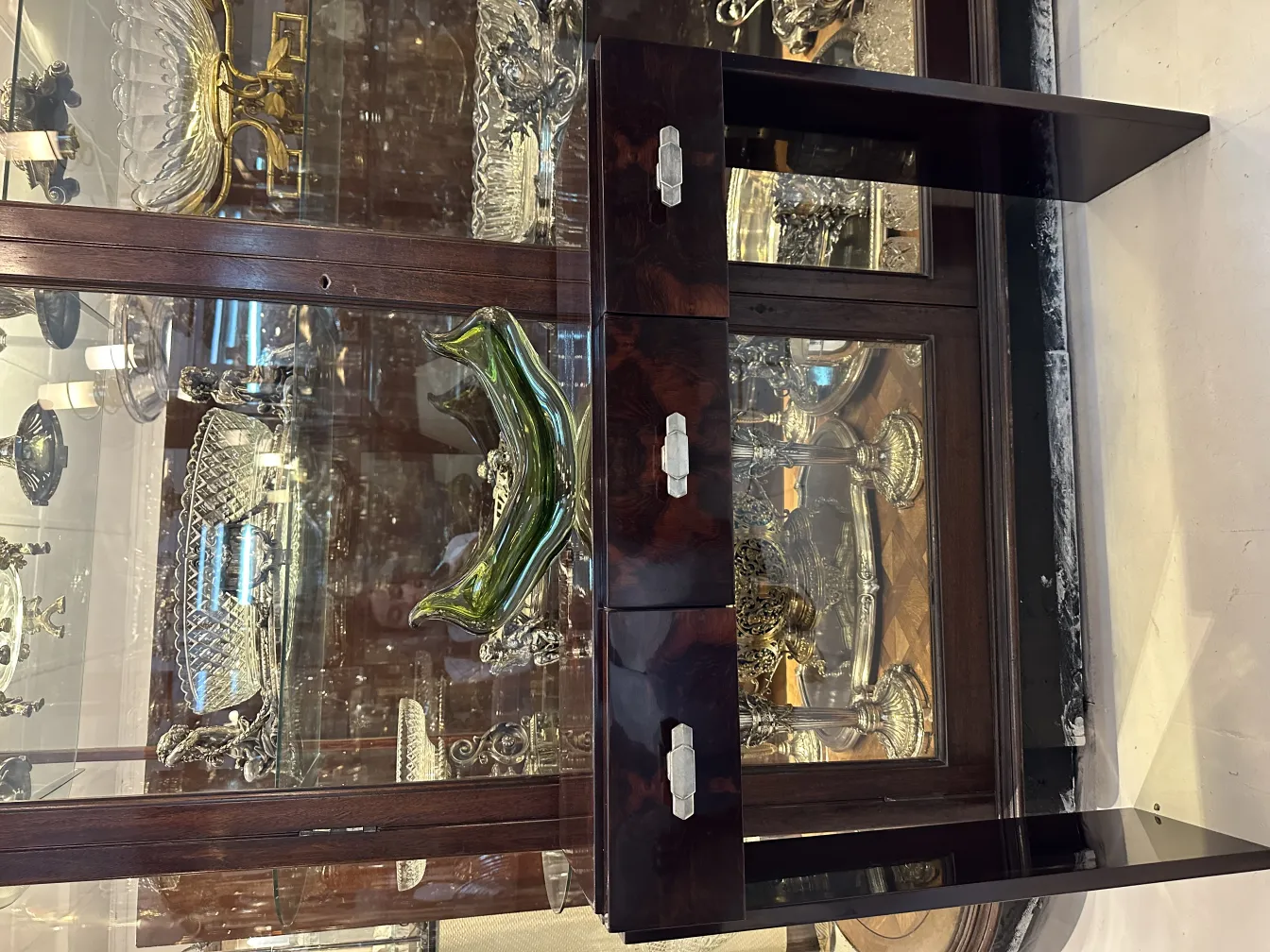 cristal de murano con forma curvada y detalles brillantes, rodeado de antigüedades