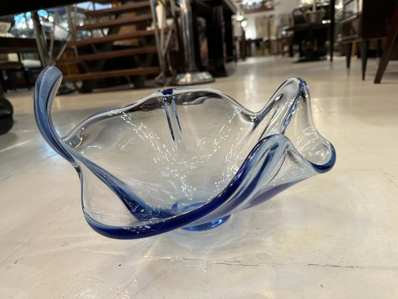 Vaso antico in vetro di Murano con forme eleganti e dettagli blu, collocato in un ambiente di antiquariato