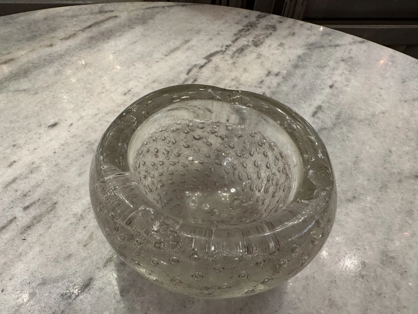 Antico vetro di Murano con bolle, forma rotonda chiara su tavolo in marmo