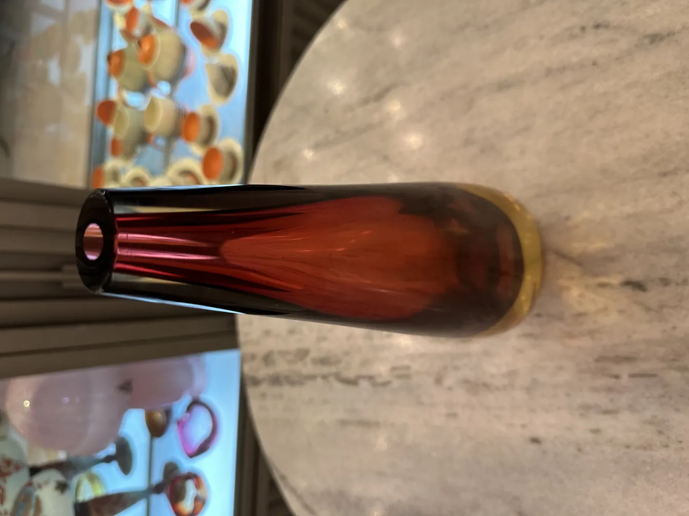 vase antico in vetro di murano in tonalità rosse e gialle, con sfondo decorativo