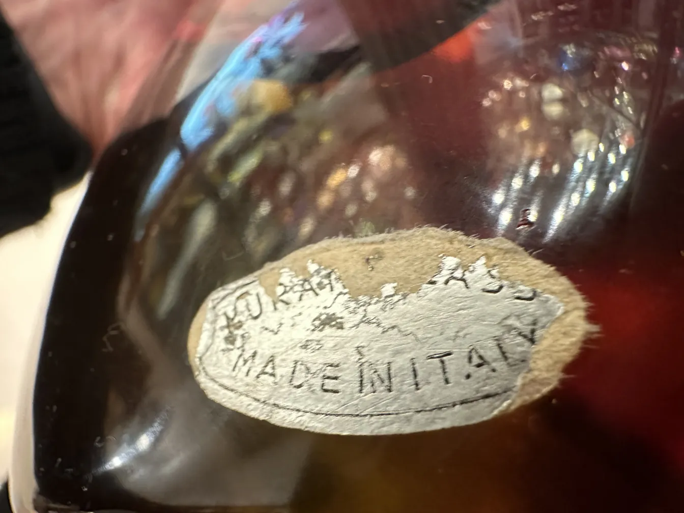 Antico vetro di Murano con etichetta alla base che dice Made in Italy, decorato in toni caldi.