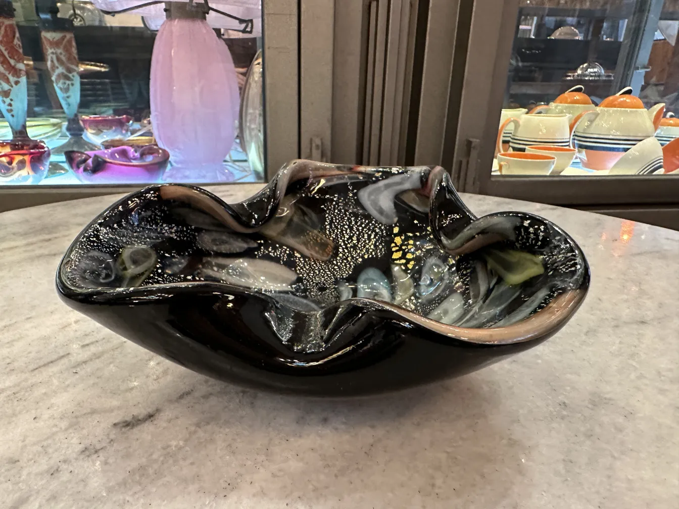 Beautiful antique Murano glass bowl with colorful details and elegant shapes, set in an antique environment.