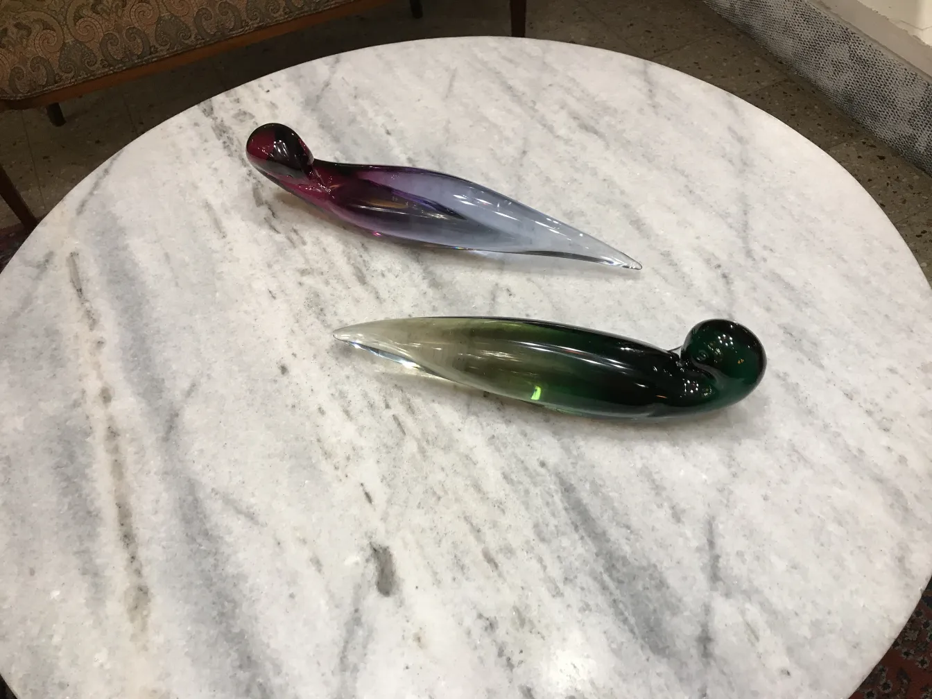 dos antiguos cristales de murano en una mesa de mármol con colores vibrantes.