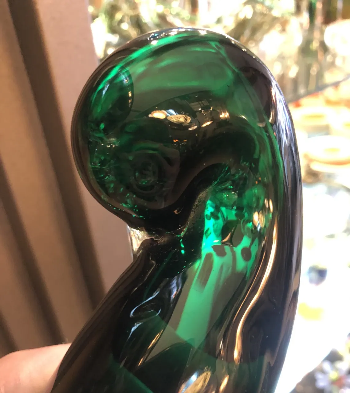 Cristal de Murano verde com formato curvado e detalhes brilhantes.