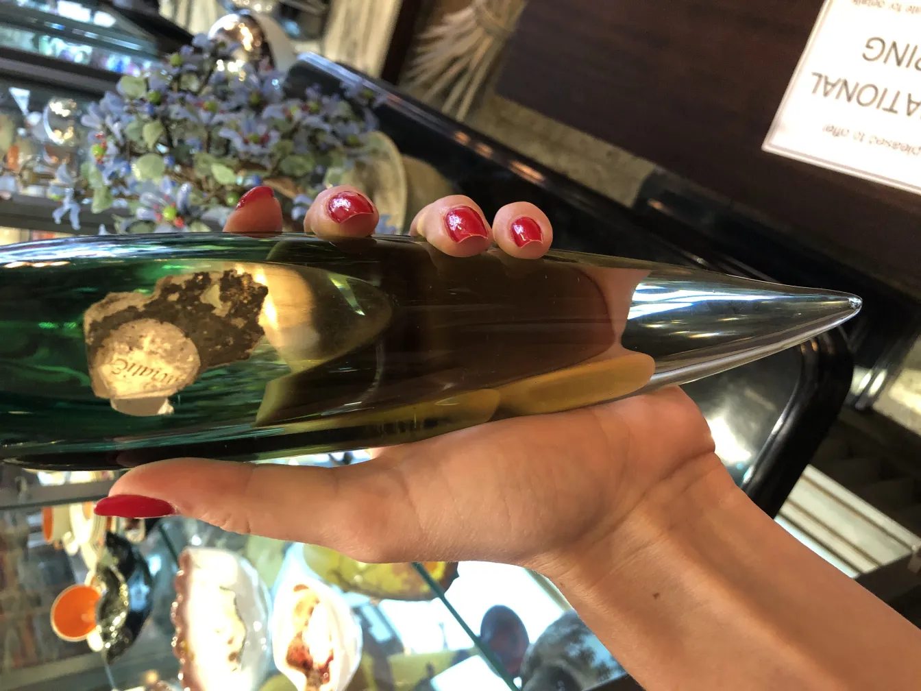 grüne spitzförmige skulptur in der hand gehalten