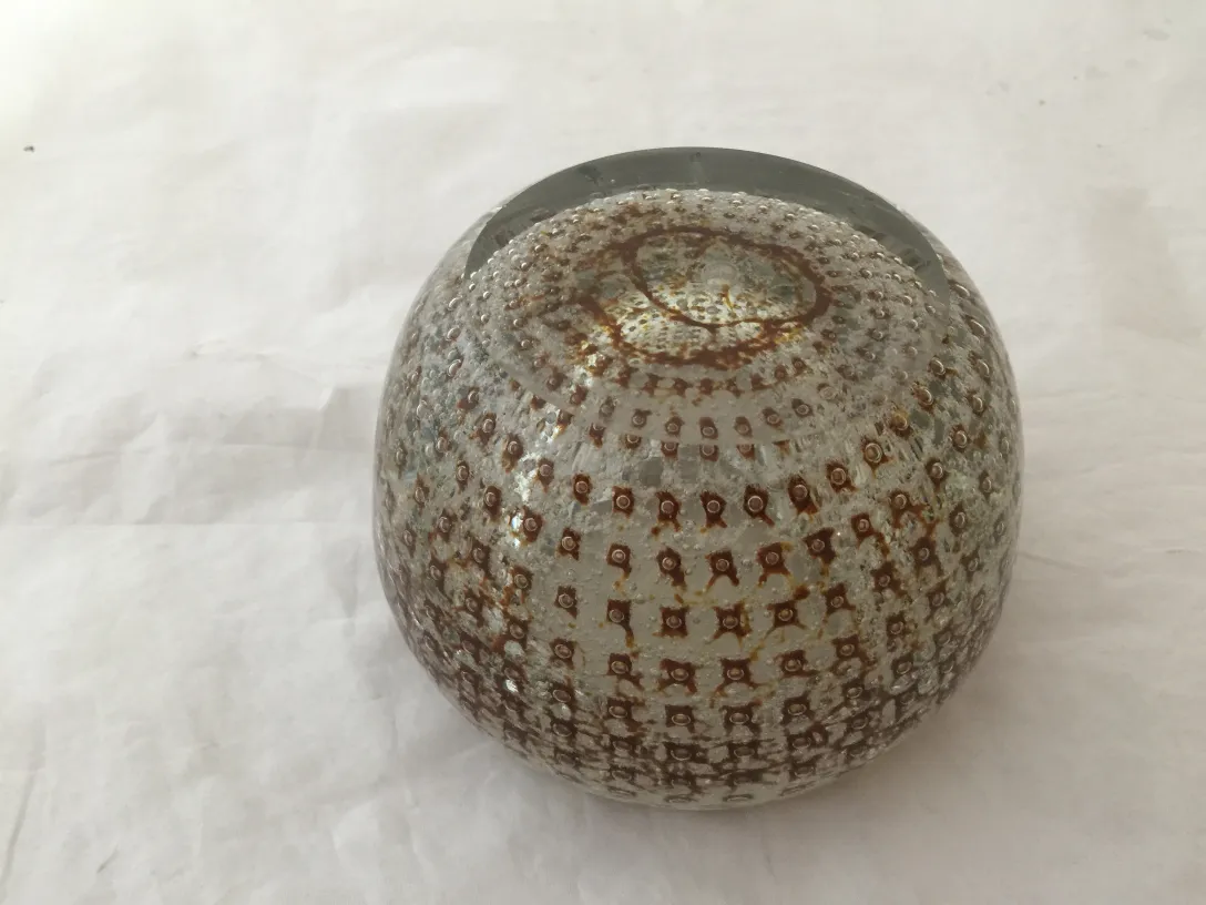 Esfera de cristal de Murano com detalhes marrons e superfície texturizada, em fundo branco.