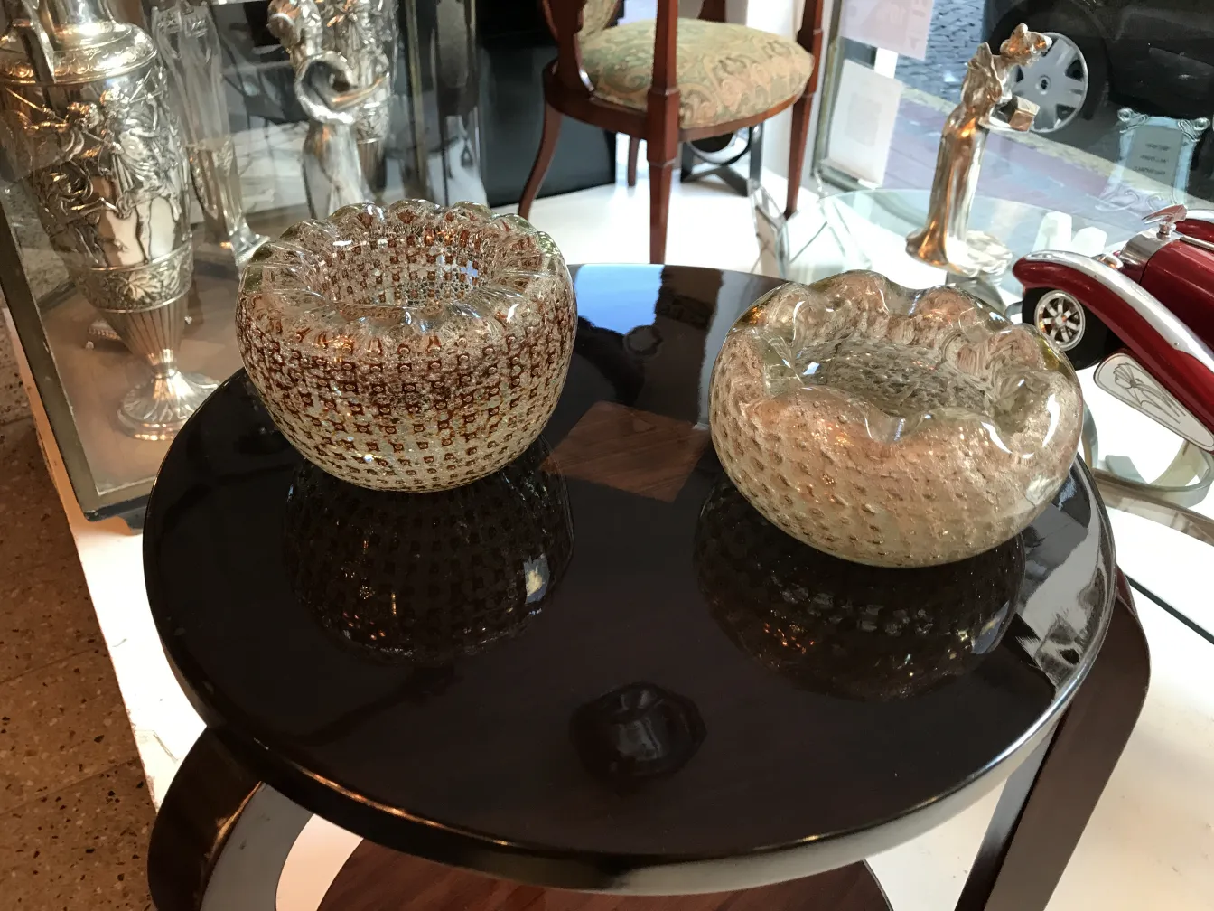 dos antiguos cristales de murano decorativos sobre una mesa negra, con detalles brillantes