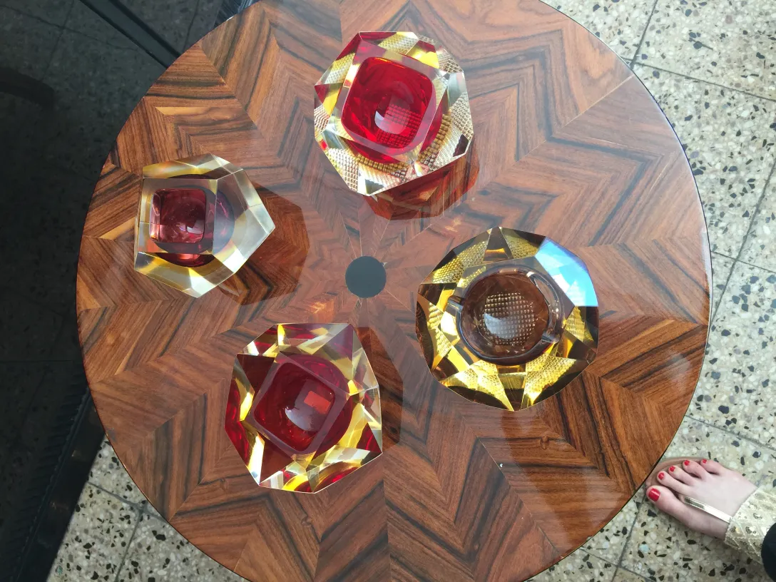 cuatro piezas de cristal de murano en tonos rojos y ámbar sobre mesa