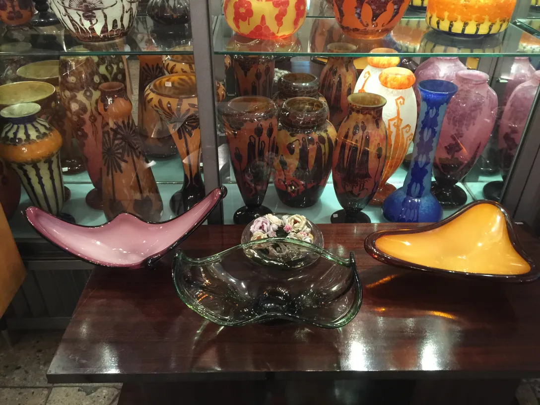 pratos decorativos de antigo cristal de murano, várias cores e formas, expostos em vitrine