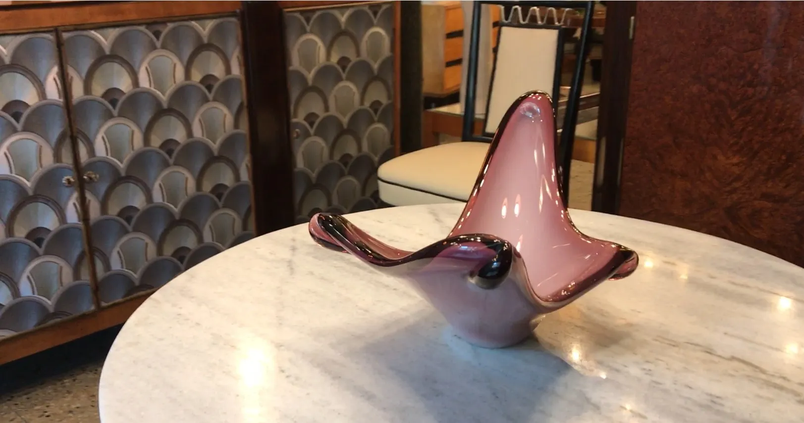 Cristal de Murano rosado em forma ondulada, ambiente elegante.