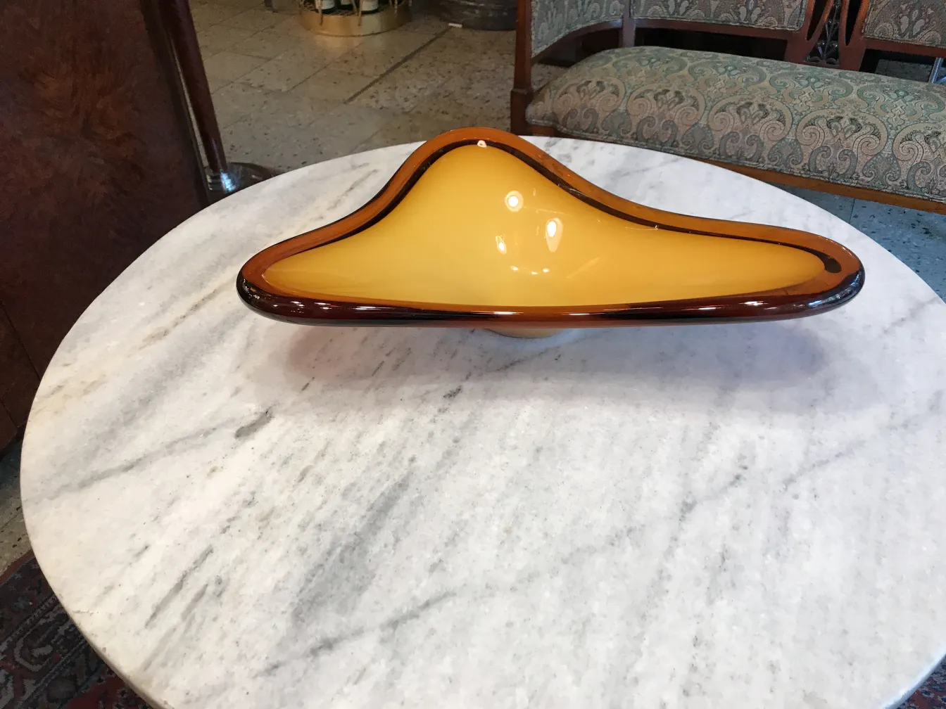 Cristal de Murano antiguo con tonos ámbar y forma distintiva sobre mesa de mármol